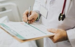 Physician noting down symptoms of a patient