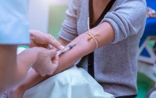 Phlebotomist takes blood sample from patient